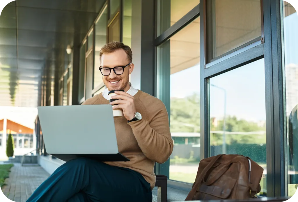 man whit a laptop and a cup of coffee